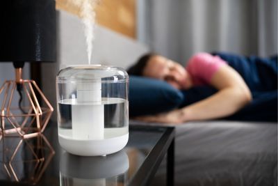 Persona durmiendo con humidificador en la habitación