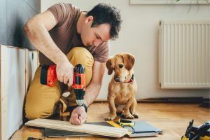 Hombre trabjando con madera con perro al lado - Cómo hacer una cama de perro