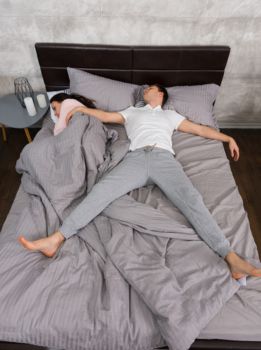 Pareja durmiendo en una cama pequeña