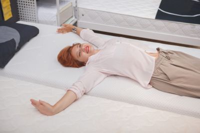 Tamaños de cama - Mujer estirada probando una cama