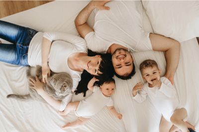 Familia con el gato sobre la cama
