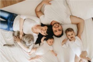 Familia con el gato sobre la cama