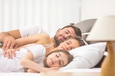 Famille dormant dans un lit king size