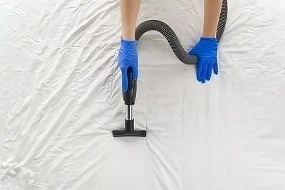 Personne nettoyant le matelas avec un nettoyeur vapeur