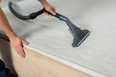 Personne passe laspirateur sur le matelas pour le nettoyer avec un nettoyeur vapeur
