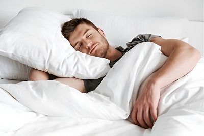 Homme dormant avec une couverture lourde
