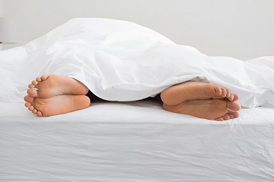 Pieds à travers la couette