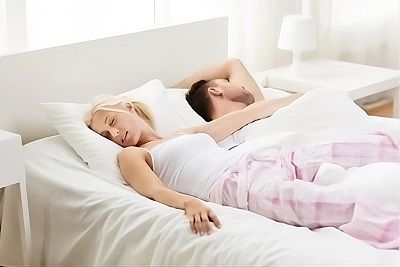 Fille dormant avec les jambes au dessus de son partenaire