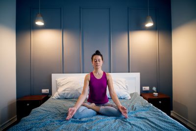 Mujer meditando sobre la cama